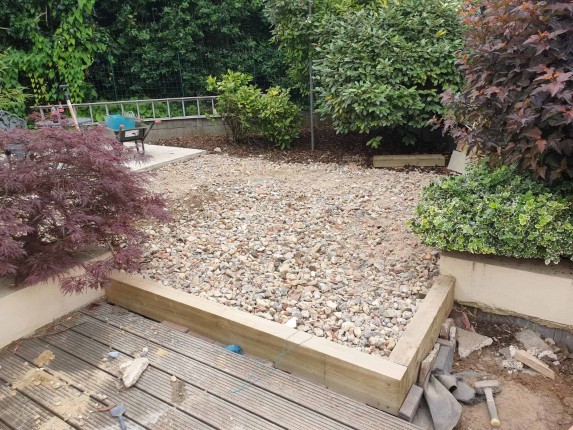 A beautifully designed garden with diverse plants, and a gravel top layer.