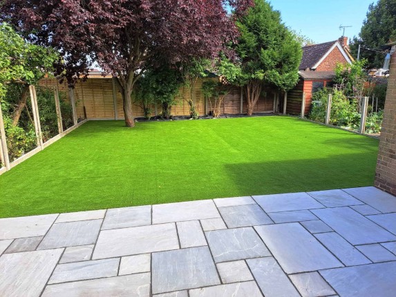 A beautifully landscaped garden with various plants, stonework, and trees.