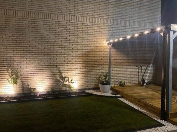 A beautifully lit garden pathway at night, creating a warm and inviting atmosphere.