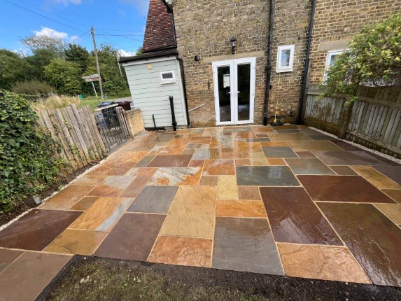 A beautifully designed patio with stone slabs in multiple shades of brown.