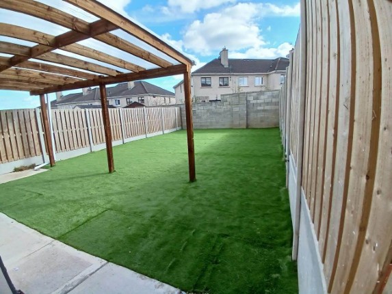 A wooden canopy looking out on a clear lawn.