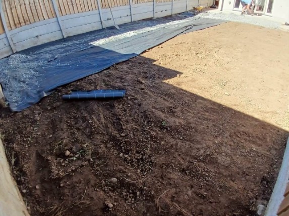 Well-prepared garden soil, ready for planting. a protective plastic cover is placed over the soil to prevent weeds and pests.